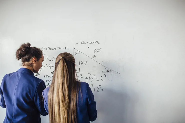 Student and teacher in front of a maths equation