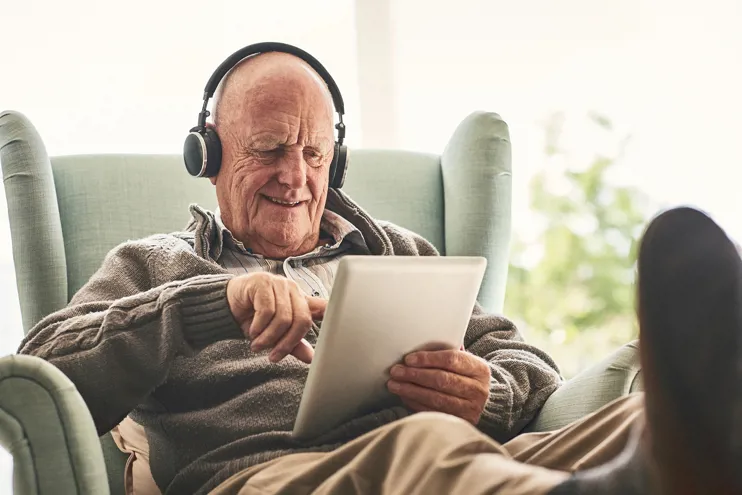 Elderly man at home using a digital tablet