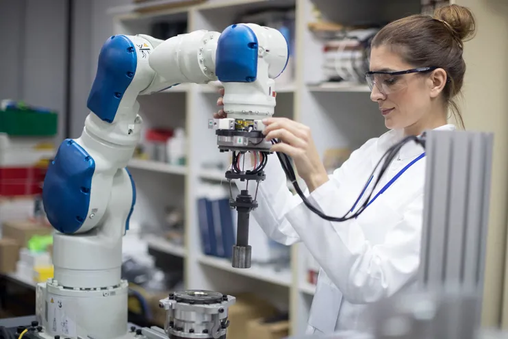 Woman engineer working on a robotic arm