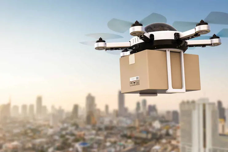 Drone delivering parcel above a cityscape