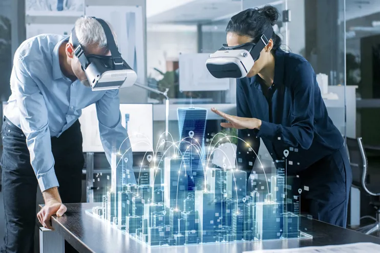 Two engineers using VR headsets look at a virtual city.
