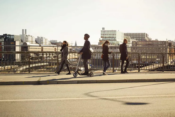 Individuals walking across a city bridge.jpg