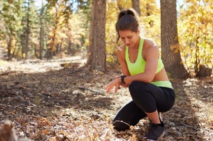 A female runner checking her fitness tracker