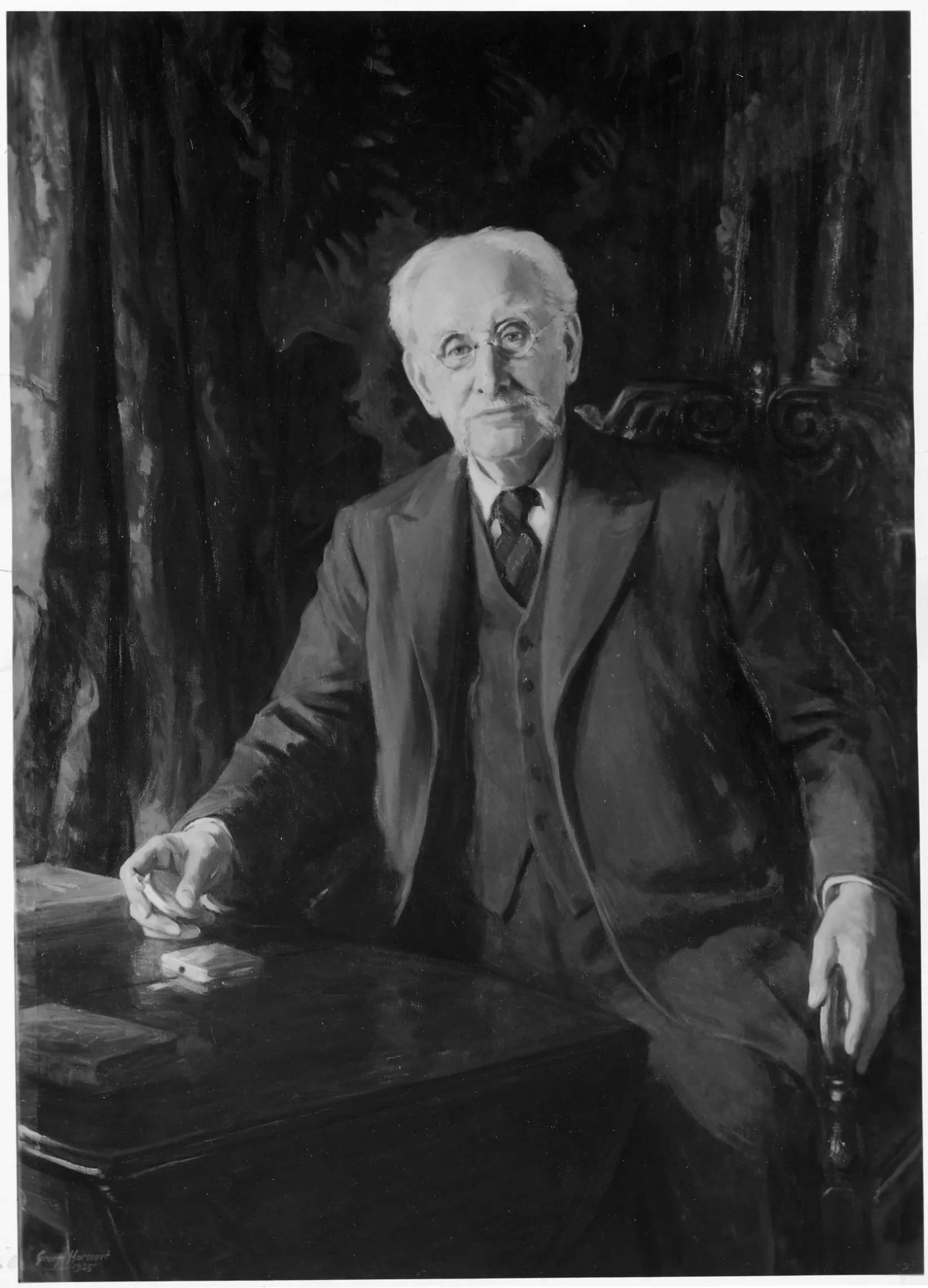 Photograph of a portrait of Colonel R E B Crompton as an older man seated at a desk, original portrait by G Harcourt.man,