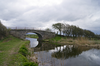 View of a bridge and its reflection across a calm river