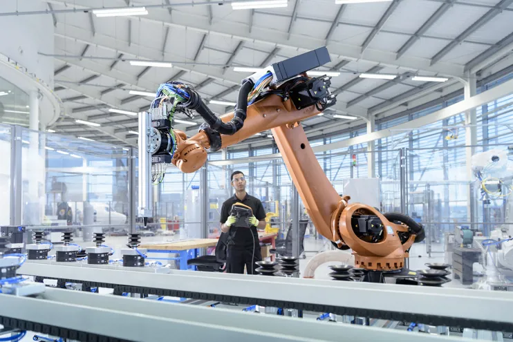 Engineer next to robotic arm on a production line