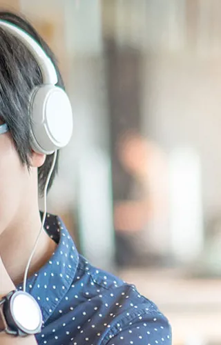 Woman in polka dot shirt wearing headphones