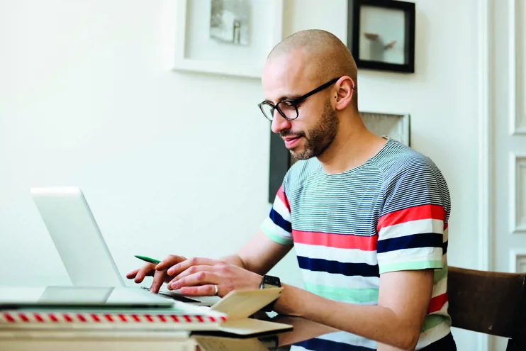 Bald man working on laptop at home